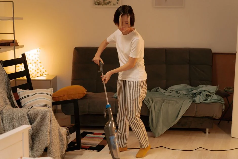 A hotel housekeeper neatly arranges fresh towels in a luxurious room setting.